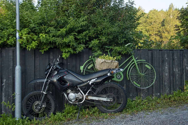 Czarny Motocykl Wiszący Zielony Rower Obok Czarnego Ogrodzenia — Zdjęcie stockowe