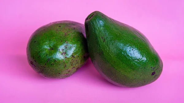Een Close Shot Van Twee Avocado Roze Achtergrond — Stockfoto