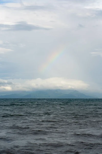 Colpo Verticale Mare Tranquillo Sotto Cielo Nuvoloso Con Arcobaleno — Foto Stock