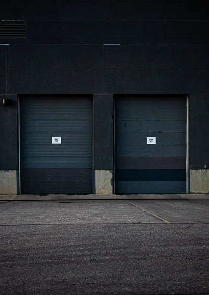 Ujęcie Pionowe Dwóch Bram Garażowych Przymocowanych Budynku Przemysłowego — Zdjęcie stockowe