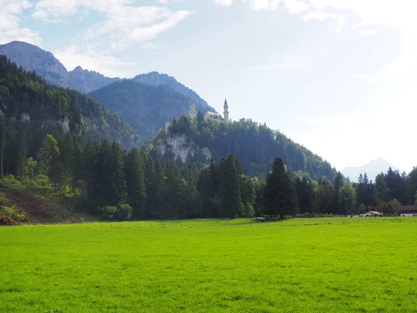 Uma Vista Baixo Até Castelo Neuschwanstein Com Prado Verde Montanhas — Fotografia de Stock