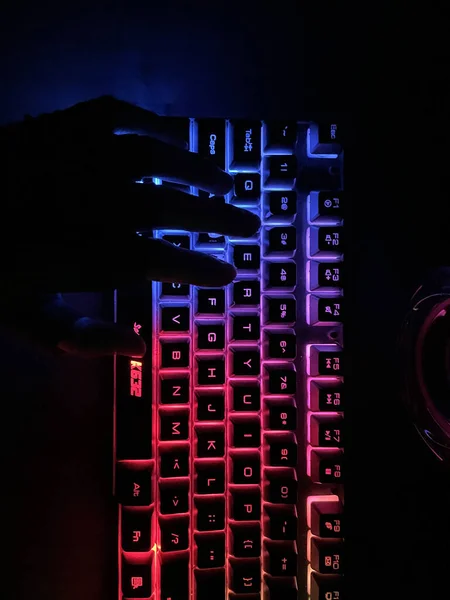 Tiro Vertical Uma Mão Digitando Iluminado Com Luzes Coloridas Teclado — Fotografia de Stock