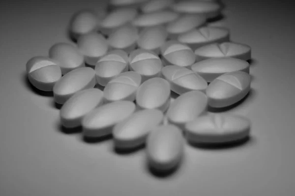 Egy Szürkeárnyalatos Közelkép Sok Gyógyszerről Egy Fehér Asztalon — Stock Fotó