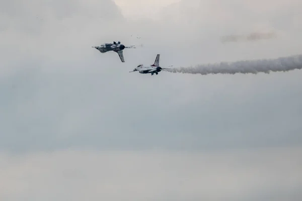 航空ショー中に暗い空に対して飛行する航空機のグループ — ストック写真