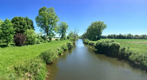 一条河流流过青绿的乡村 在蔚蓝晴朗的天空下流过 — 图库照片