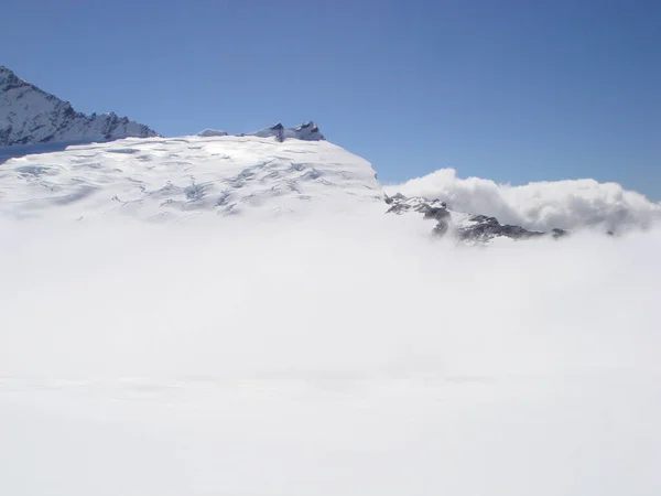 눈덮인 산봉우리의 하늘로 산비탈에서 날리는 — 스톡 사진