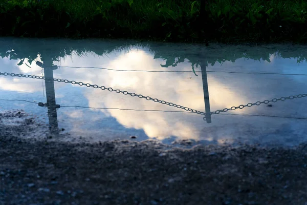 Una Pequeña Plash Con Reflejo Del Cielo Nublado Postes Metal —  Fotos de Stock