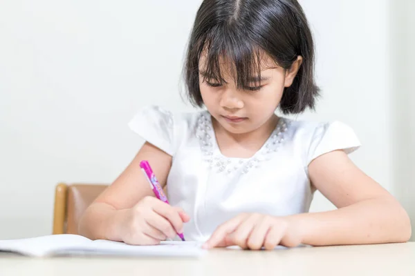 Ein Asiatisches Kleines Mädchen Sitzt Schreibtisch Und Schreibt Ihr Werbebuch — Stockfoto