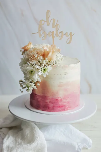 白いテーブルの上にトッパーと花の美しいブーホパステルケーキ — ストック写真