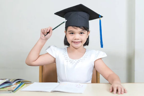 Portrait Cheerful Asian Little Girl Mortarboard Sitting Desk — Stock Photo, Image