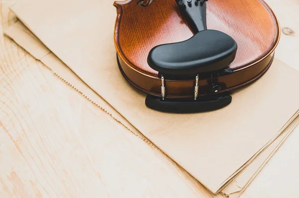 木製の卓上と茶色の紙の背景にエレガントなアコースティックバイオリンのトップビュー — ストック写真