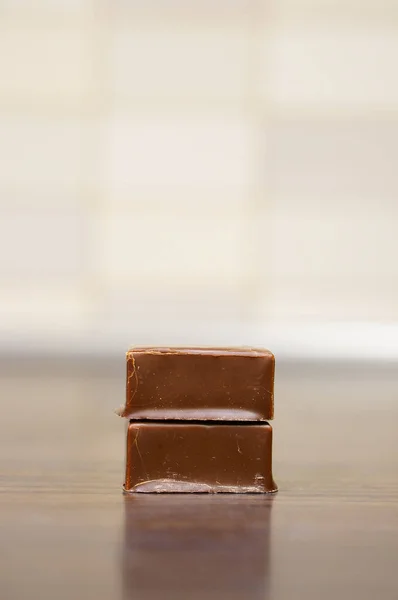 Yansıtıcı Bir Masanın Üstünde Iki Küp Çikolatanın Yakın Çekimi — Stok fotoğraf