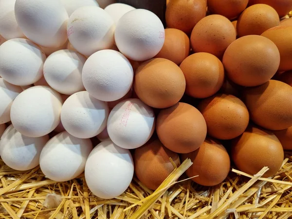 稻草上有白色和褐色蛋的摊子 — 图库照片