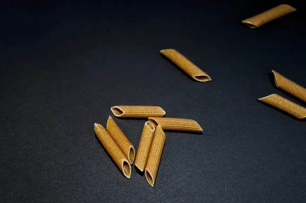 Eine Nahaufnahme Von Ungekochter Penne Pasta Auf Dunkler Oberfläche — Stockfoto