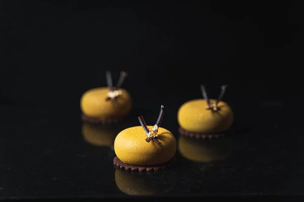 A selective of yellow round cookies on a black table