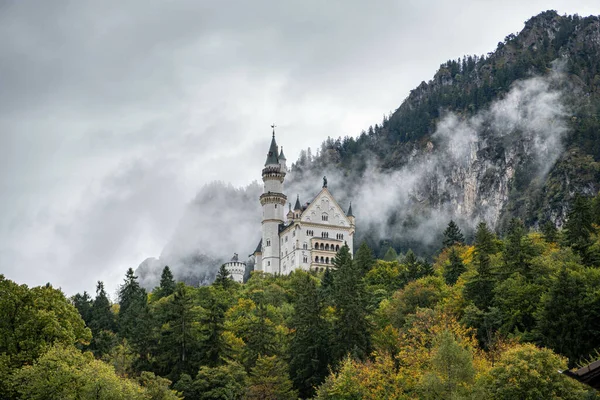 山と緑の森の上にあるドイツ ノイシュヴァンシュタイン城の美しい雪景色 — ストック写真