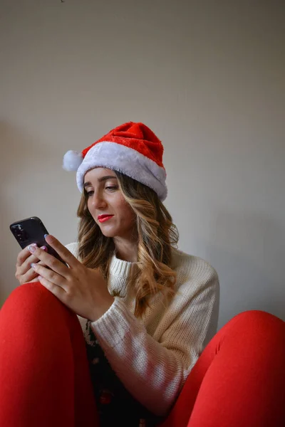 Uma Mulher Feliz Chapéu Papai Noel Navegando Seu Telefone — Fotografia de Stock