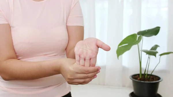 アジアの女性はストレッチと優しく仕事から痛みを軽減するために理学療法を行う彼女の指先を引っ張っ — ストック写真