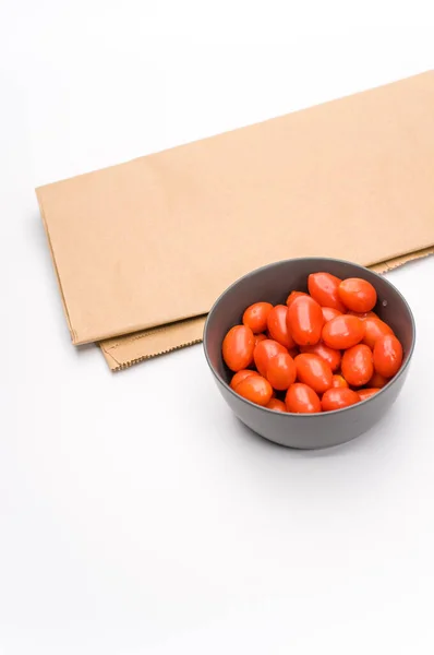 Dark Gray Stoneware Bowl Full Datterini Tomatoes Kraft Paper White — Stock Photo, Image