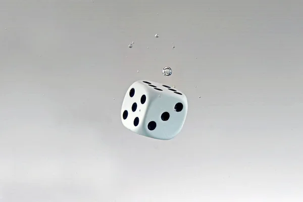 白い背景に水滴の付いた落下するダイスのクローズアップ — ストック写真