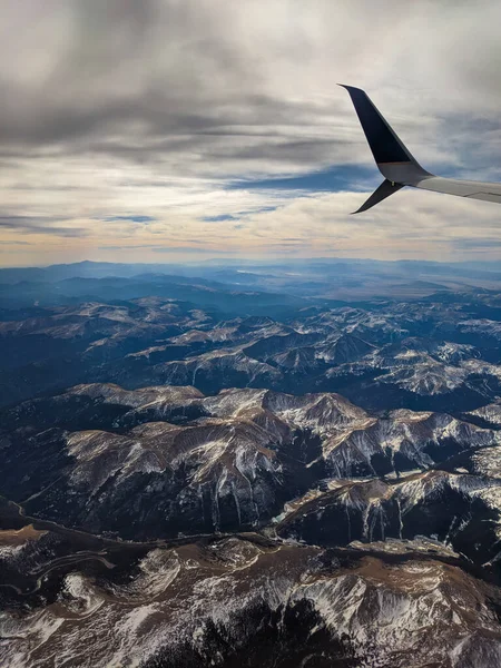 Tiro Vertical Uma Asa Avião Voando Sobre Montanhas Sob Céu — Fotografia de Stock
