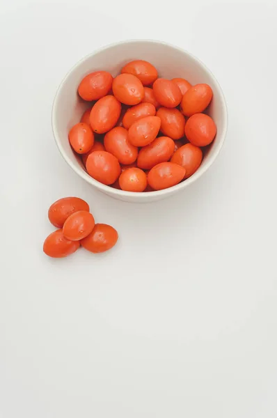 白色装饰的石器碗 盛满了西红柿 放在白色的表面 上面有文字空间 — 图库照片