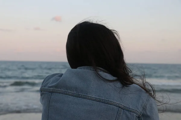 夕暮れ時の雲海を眺めながら穏やかな海の景色を楽しむ若い女性のリアビュー — ストック写真