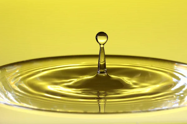 Närbild Bild Droppe Vatten Vattenyta Som Resulterar Vattenskulpturer Gula Färger — Stockfoto
