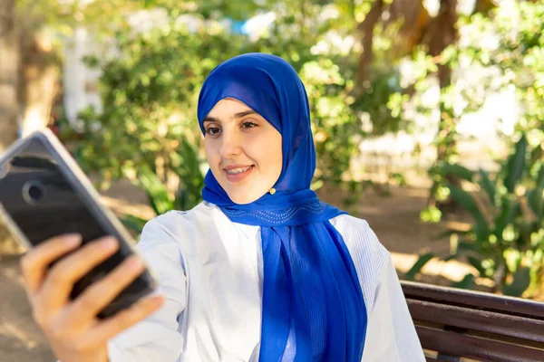 Портрет Молодой Мусульманки Хиджабе Сидящей Скамейке Парке Делающей Селфи Копирующее — стоковое фото