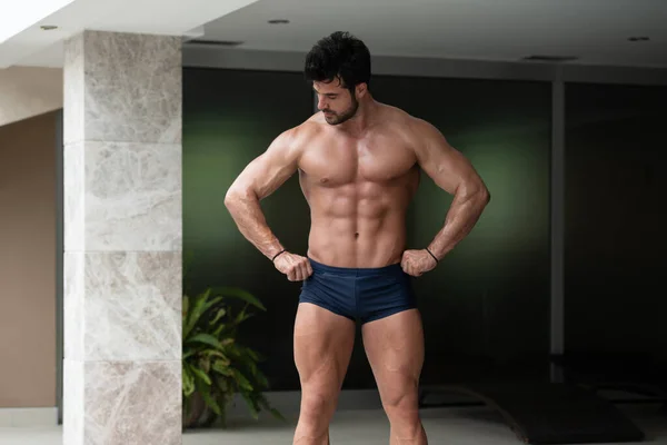 Hombre Joven Saludable Pie Músculos Fuertes Flexionantes Mientras Usa Pantalones — Foto de Stock