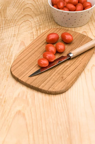 Tazón Lleno Tomates Datterini Con Tabla Cortar Cuchillo Una Superficie —  Fotos de Stock