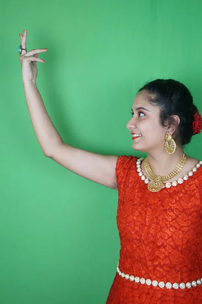 Piękna Kobieta Pozuje Czerwonej Sukience Biżuterią Makijażem Przeciwko Zielonej Ścianie — Zdjęcie stockowe
