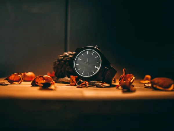 木の表面に時計と乾燥葉のクローズアップショット — ストック写真