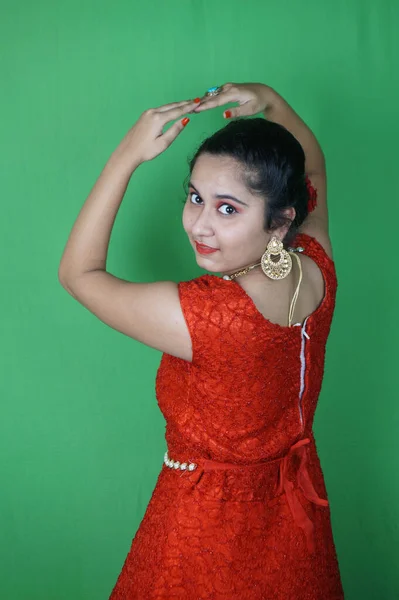 Красива Жінка Позує Червоній Сукні Прикрасами Макіяжем Зеленій Стіні — стокове фото
