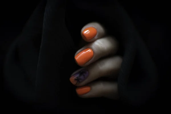 어두운 배경에 여성의 손톱에 주황색 매니큐어의 클로즈업 — 스톡 사진