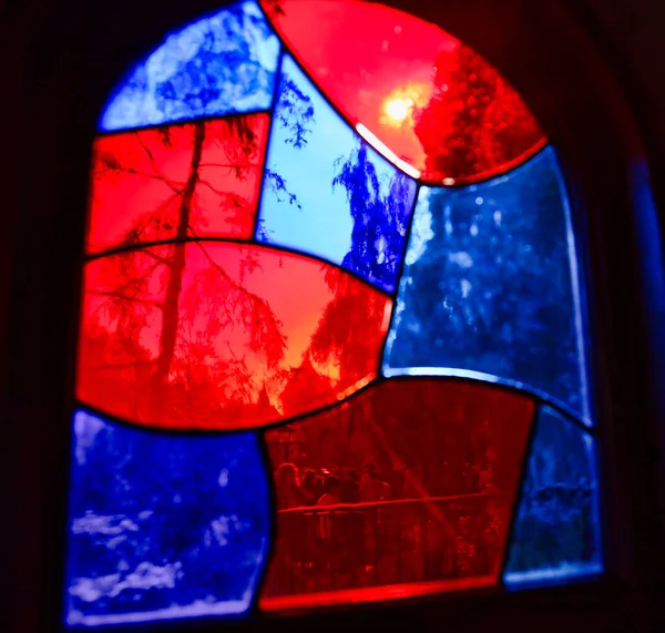 青と赤のステンドグラスに差し込む太陽の光のクローズアップ — ストック写真