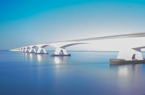 Een Reflecterend Blauw Meer Zeelandbrug Onder Een Heldere Hemel — Stockfoto