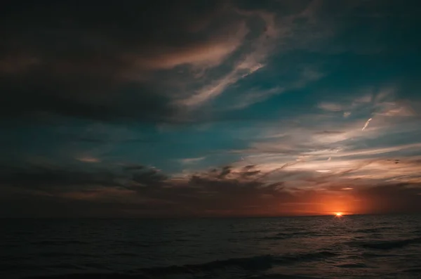 Uma Vista Hipnotizante Mar Sob Céu Sombrio Pôr Sol — Fotografia de Stock