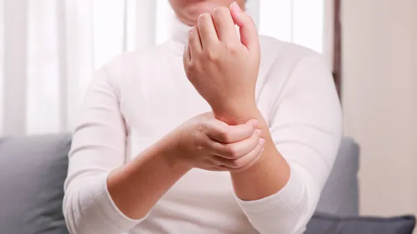 Kvinne Hvit Skjorte Sitter Sofaen Masserer Armer Håndledd Slappe Lindre – stockfoto