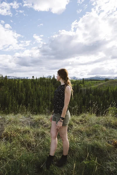 森の中に立っている若い女性の美しい垂直ショット — ストック写真