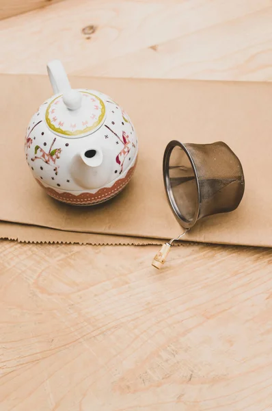 Metal Tea Strainer Decorated Tea Pot Kraft Paper Wooden Background — Stock Fotó