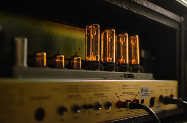 A closeup of amp tube on an electronic amplifier under the lights