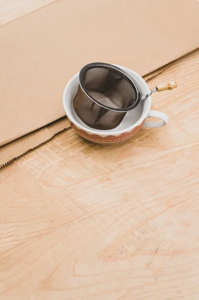 Metal Tea Strainer Decorated Tea Cup Kraft Paper Wooden Background — Stock Fotó