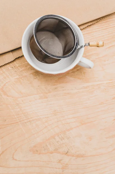 Metal Tea Strainer Decorated Tea Cup Kraft Paper Wooden Background — Stock Fotó