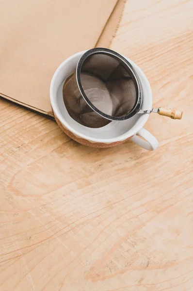 Metal Tea Strainer Decorated Tea Cup Kraft Paper Wooden Background — Foto Stock