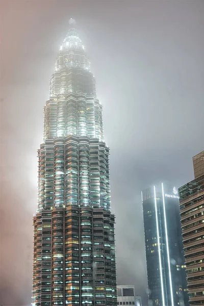 在一个雨夜 吉隆坡的Petronas塔的照片 那里的天空低垂 覆盖着塔的顶部 — 图库照片