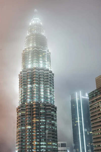 雨の夜にクアラルンプールのペトロナスタワーの写真です空が低くぶら下がって塔の上を覆っていました — ストック写真