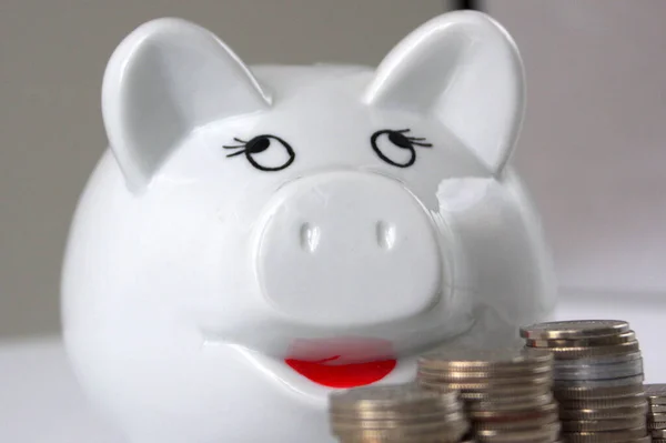 Closeup White Piggy Bank Stack Coins Blurry Background – stockfoto