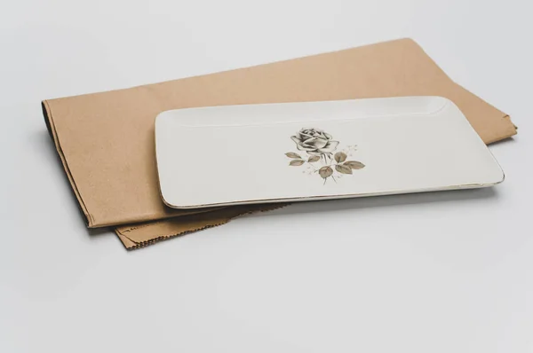 茶色の紙と白い背景の上に細かく装飾された石器料理 — ストック写真