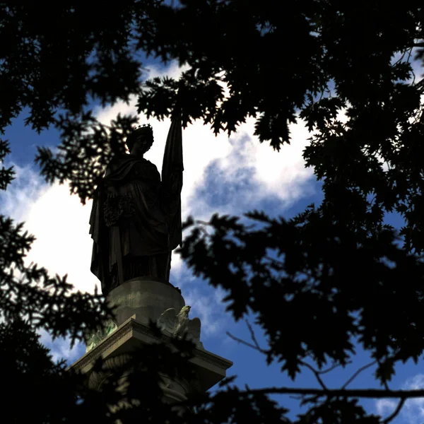 Low Angle Shot Statue Surrounded Tree Branches Cloudy Sky — Foto de Stock